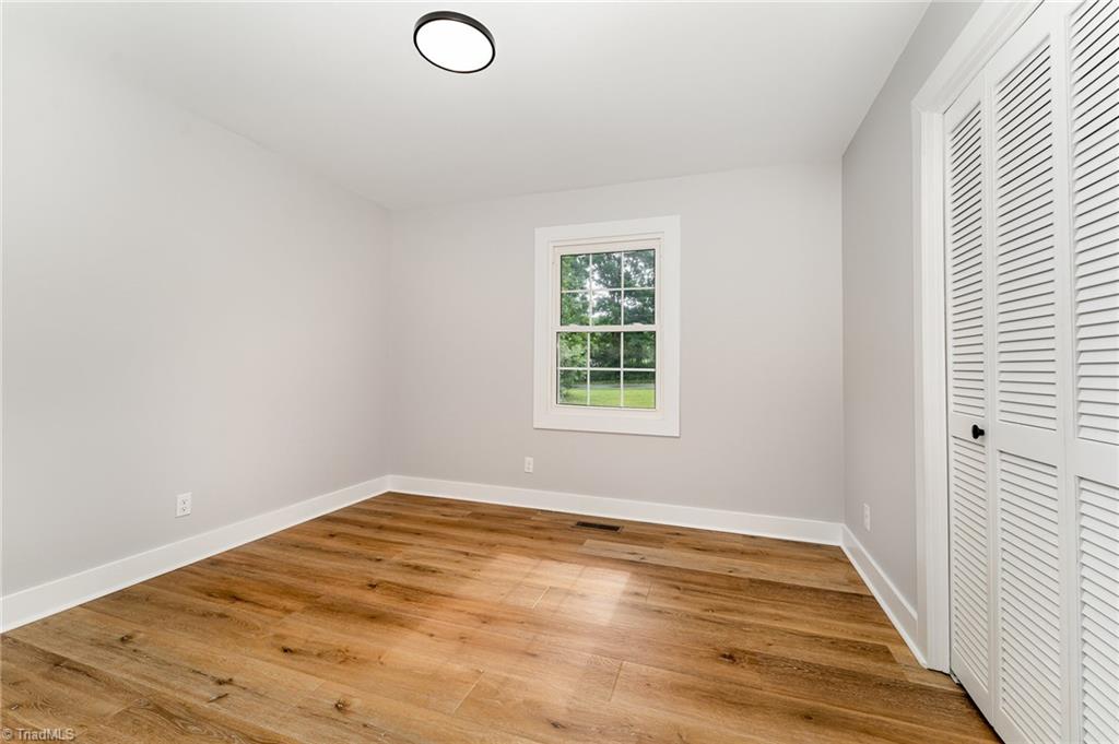 Bedroom interior painting and LVP flooring after photo in Summerfield, NC